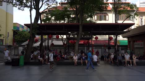 People-walk,-relax-and-play-chess-under-a-multipurpose-pavilion-in-Kreta-Ayer-Square-in-Chinatown,-Singapore