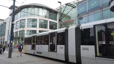 Facade-of-the-Arndale-shopping-centre-in-Manchester-and-tram-moving-past,-Manchester,-UK