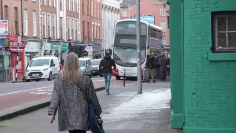 Woman-walking-to-bus-station-on-Washington-street,-Cork-City,-Ireland