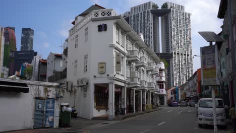 Street-scene-of-renovated-traditional-shophouses-against-the-background-of-The-Pinnacles-at-Duxton-in-Chinatown-area,-Singapore