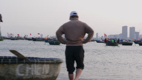 Dolly-shot-of-a-collection-of-boats-with-fishermen-heading-out-to-sea-in-Da-Nang