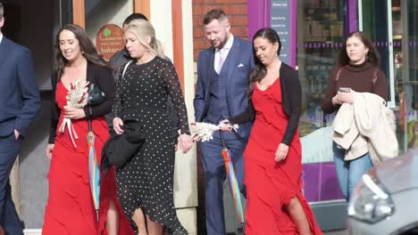 A-group-of-nicely-dressed-people-passing-by-on-a-Washington-Street-in-Cork-City,-Ireland