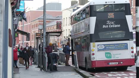 Bus-Eireann-Bus-Parado-En-La-Estación-De-Autobuses-Con-Gente-En-La-Calle-Washington,-Ciudad-De-Cork,-Irlanda