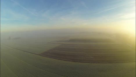 Luftaufnahme-Einer-Gefrorenen-Landschaft-Mit-Goldenem-Sonnenaufgang-Durch-Nebel