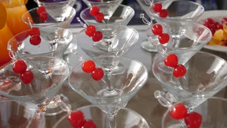 Pan-over-a-table-of-martini-cocktails-with-cherry-garnishes-at-a-party