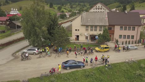 Rotating-aerial-shot-of-cyclists-preparing-for-a-mountain-race-in-a-town