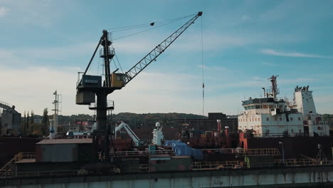 Drohne-Fliegt-Um-Kran-Herum,-Während-Sie-Frachtschiff-In-Der-Werft-Belädt