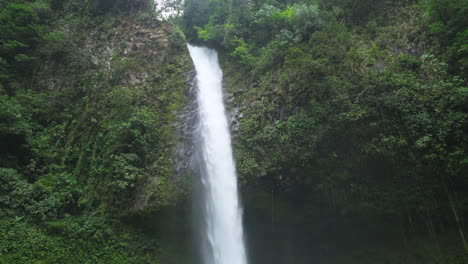 La-Fortuna-Waterfall-flowing-in-the-lush-Costa-Rica-rainforest,-Tilt-Shot