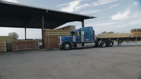 Peterbilt-Semi-Truck-turning-in-lumber-yard-pulling-trailer