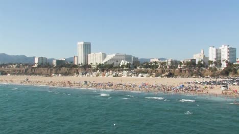 Una-Hermosa-Toma-En-Alta-Mar-De-La-Famosa-Playa-De-Santa-Mónica-Con-Muchos-Bañistas-Disfrutando-Del-Verano