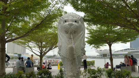 Small-Merlion-Singapore-fontaine-between-trees-and-tourist-slow-motion