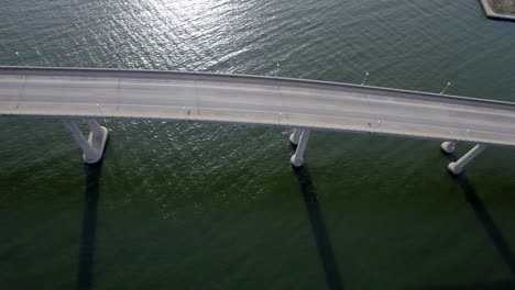 Birds-eye-view-ultra-wide-looking-down-at-car-traffic-crossing-bridge-over-Chesapeake-Bay-Severn-River-in-Annapolis