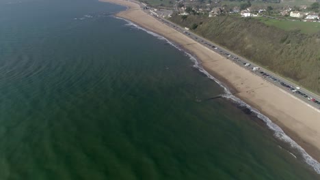 Angled-aerial-over-the-vast-length-of-Exmouth-beach-in-East-Devon,-UK