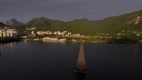 Panoramic-view-of-the-Rio-de-Janeiro-city-lake-at-sunrise-with-in-the-middle-of-the-lake-the-2018-tallest-floating-Christmas-tree-and-the-natural-surroundings-and-landmarks-in-the-background