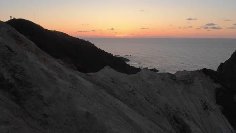 drone-flight-over-a-cliff-into-the-sunset