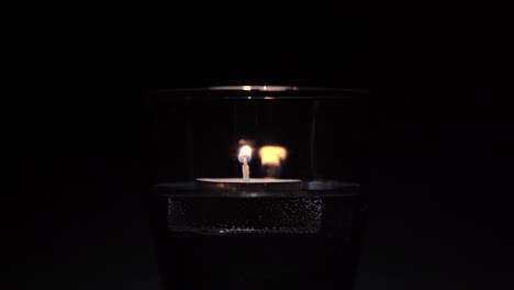 Brennender-Lampion-In-Einem-Glas-Wasseroberfläche