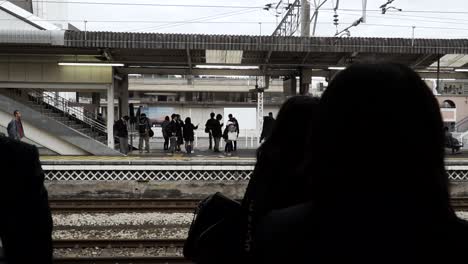 Silhouetten-Von-Menschen,-Die-Am-Bahnhof-In-Japan-Warten