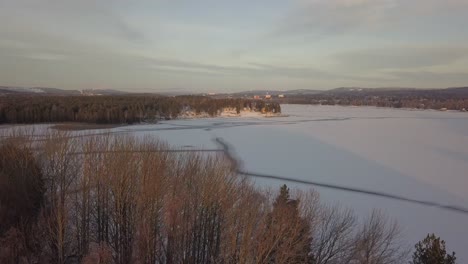 Frozen-lake-in-Falun,-Sweden-during-a-cold-winter-in-December,-filmed-with-a-drone