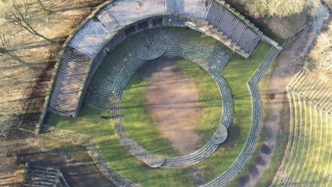 Drone-Subiendo-Con-Vista-Desde-El-Suelo-De-Los-Escalones-Del-Teatro-Al-Aire-Libre-Del-Círculo-Histórico-En-Heidelberg,-Alemania