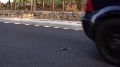 Car-tires-driving-over-mobile-smart-phone-gorilla-glass-on-normal-road-with-tarmac---wide-angle