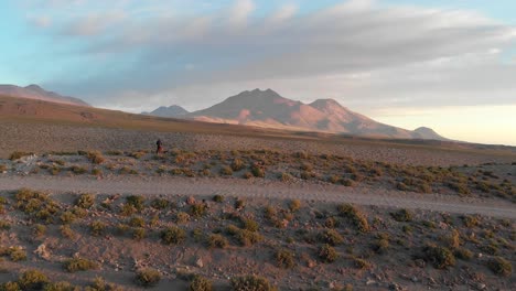 Luftaufnahme-Einer-Unbefestigten-Straße-Mit-Einem-Einsamen-Reisenden-In-Der-Nähe-Einer-Klippe-In-Der-Atacama-Wüste,-Chile,-Südamerika