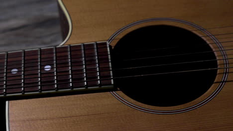 Moving-slider-shot-from-left-to-right-of-an-acoustic-guitar-from-the-fret-board-to-the-bridge