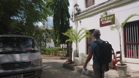 Tourist-Mit-Rucksack-Läuft-Auf-Der-Straße-Mit-Bars-Und-Hotels-In-Sansibar-Stone-Town