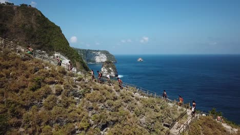 Drone-shot-following-a-group-of-hikers-hiking-up-the-ridge-coming-from-KelingKing-Beach