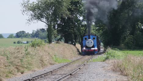 Luftaufnahme-Eines-Thomas-The-Tank-Engine-Mit-Passagierwagen,-Die-Entlang-Der-Amischen-Landschaft-Schnaufen