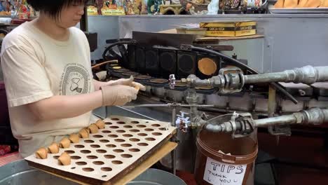 A-lady-making-fortune-cookies-at-the-famous-"Golden-Gate-Fortune-Cookie-Company"-in-San-Francisco's-historic-Chinatown