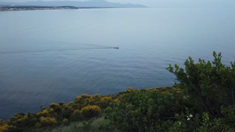Ein-Kleines-Motorboot-Fährt-Rechts-Von-Einem-Hügel-In-Die-Blaue-Seeansicht
