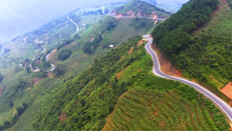 Aerial-dolly-forward-shot-of-vehicles-traveling-on-a-dangerous-mountain-road