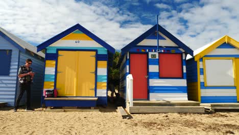 Tourists-walking-and-taking-photo-at-Brighton-Bathing-Boxes,-Melbourne,-Australia