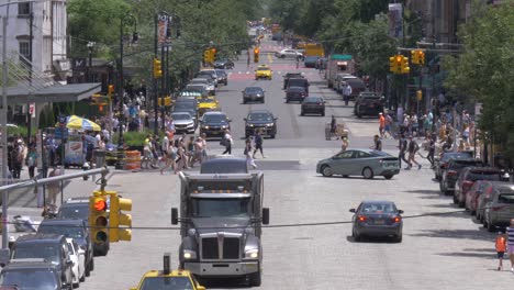 Traffic-at-the-intersection-of-West-14th-Street-and-9th-Avenue-in-Chelsea,-Manhattan,-New-York-City,-filmed-in-180-fps-slow-motion-from-the-High-Line