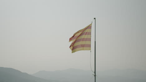 Die-Katalanische-Flagge-Weht-Im-Wind-In-El-Port-De-La-Selva-Und-Die-Berge-Im-Hintergrund