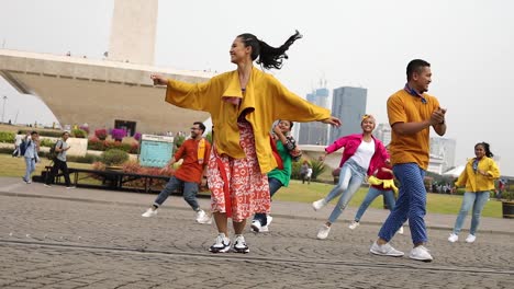 Un-Grupo-De-Jóvenes-Adolescentes-Y-Jóvenes-Bailando-Junto-Con-El-Gran-Monumento-De-Las-Monas-Detrás-De-Ellos