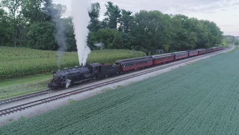 Aerial-View-on-a-Steam-Passenger-Train-Waiting-at-a-Station-in-the-Amish-Countryside-on-a-Summer-Day