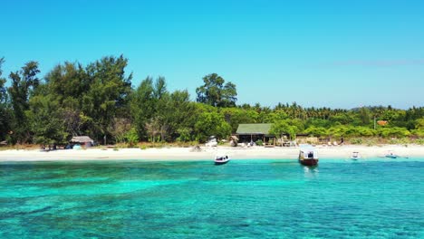 Ruhiger-Exotischer-Strand-Mit-Weißem-Sand,-Gesäumt-Von-Grünen-Tropischen-Bäumen-Und-Türkisfarbener-Lagune-Mit-Klarem,-Ruhigem-Wasser,-Wo-Fischerboote-In-Jamaika-Schwimmen