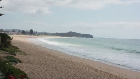Wide-side-angle-slow-motion-shot-of-mid-morning-at-Narrabeen-Beach-in-Sydney-Australia