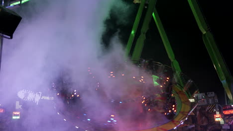 Giant-spinning-carousel-with-smoke,people-having-fun,static-wide-shot