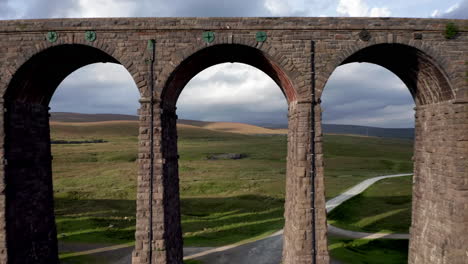 Aerial-Shot-Flying-Backwards-Through-Ribblehead-Viaduct-Revealing-the-Stone-Structure-and-Clay-Pits