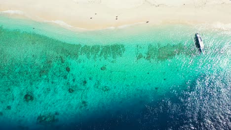 Tranquila-Agua-Cristalina-Transparente-Sobre-Un-Hermoso-Patrón-De-Arrecifes-De-Coral-Y-Guijarros-En-El-Fondo-Del-Mar-Visto-A-Través-De-La-Laguna-Turquesa-Donde-Los-Barcos-Flotan-En-Las-Seychelles