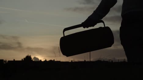 Carrying-retro-portable-radio-music-player-at-sunset