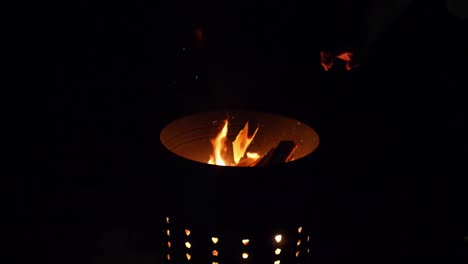 Steel-brazier-with-fire-burning-in-ritual-burning-of-paper-items-in-slow-motion