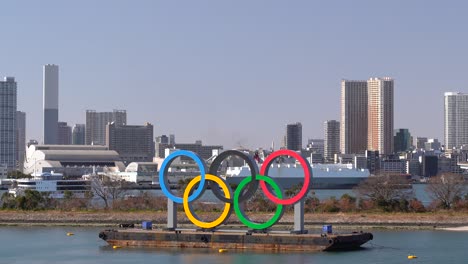 Schild-Der-Olympischen-Spiele-In-Der-Bucht-Von-Tokio-Mit-Vorbeifahrenden-Schiffen-Im-Hintergrund-An-Einem-Hellen-Und-Sonnigen-Tag