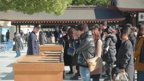 Japanese-people-praying-at-Meiji-Jing-Shrine-at-Yoyogi-Park-in-Shibuya,-Tokyo,-Japan