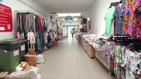 Dolly-inside-Chinese-trade-center-Wolka-Kosowska,-rows-of-clothing-for-sale,-Slow-motion