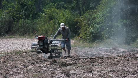 Wide-Exterior-Static-Shot-of-a-Farmer-on-Ploughing-Machine-the-Field-in-the-Day