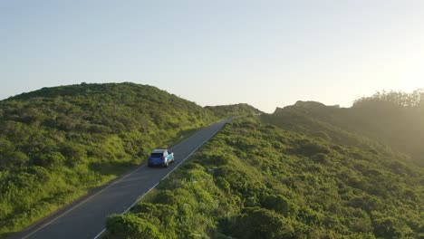 Blauer-Porsche-Macan-Fährt-Zur-Goldenen-Stunde-Durch-Die-Landzungen-In-San-Francisco,-Kalifornien,-Luftaufnahme