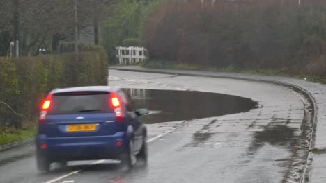 Los-Vehículos-Conducen-Alrededor-De-La-Peligrosa-Curva-De-La-Esquina-De-La-Carretera-Inundada-De-Flash-Tormentoso-Uk